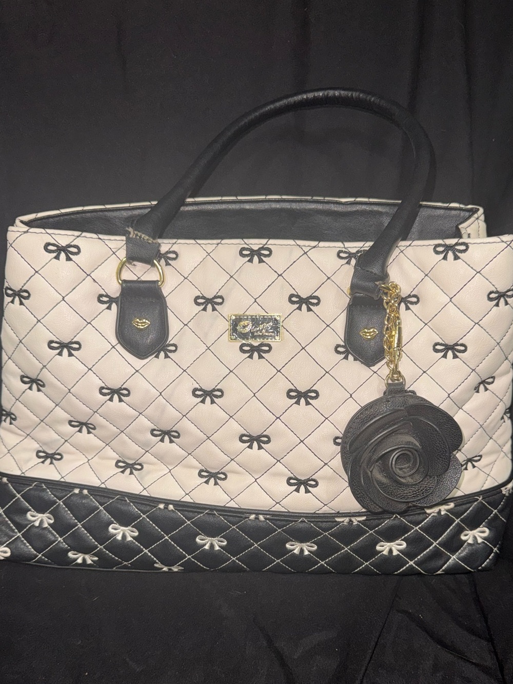 This is a Luv Betsey by Betsey Johnson black and white quilted bow pattern tote